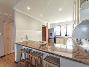 een keuken met een groot aanrecht met krukken bij Ocean Blue Stay in St James +47 foto's