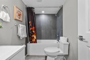 Un baño con inodoro, bañera y lavabo. en Peaceful 1BHK - Maple, en Edmonton