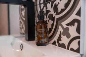 a bottle of soap sitting on a sink in front of a mirror at Chobe Princess by Mantis in Kasika