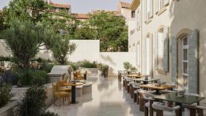 un cortile con tavoli e sedie in un ristorante di Hôtel de La Fontaine a Lourmarin