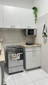 a kitchen with a stove and a microwave at T2 Vacation in Mindelo in Mindelo