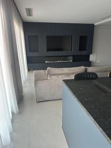Una sala de estar con un sofá y un televisor de pantalla plana. en Boa Vista Apartment, en Prainha