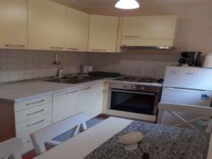 a kitchen with white cabinets and a table and a sink at Apartment in Rovinj - Istrien 43942 in Štanga