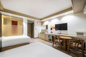 a hotel room with two beds and a flat screen tv at Jeonju Nabi in Jeonju