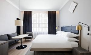 Un dormitorio con una cama, un escritorio y un sofá. en Luxury Collection Hotel, en Sevan