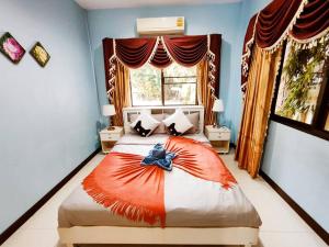 ein Schlafzimmer mit einem großen Bett und einer orangefarbenen Decke in der Unterkunft Yellow hourse Luxury Pool Villa in Chiang Mai + 14 Fotos