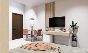 Habitación con escritorio y mesa con sillas. en SCN City Hotel Rayong, en Ban Chang