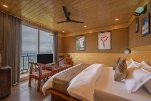 a bedroom with a large bed and a balcony at The Charvi Retreat Kufri I Vacations I Conference I MICE I Family Events I Open Air Terrace I Sky Bonfire I Wooden Rooms With Pvt Balconies I Kufri by Exotic Stays in Kūfrī