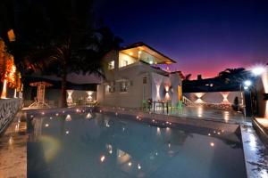a swimming pool in front of a house at night at EMPYREAN STAYS ll 3bhk AC MARSHAL VILLA ll in Lonavala