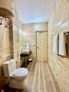 a bathroom with a toilet and a sink at The Kufri Mansion I Three-Bedroom Villa l Charvi Retreat by Exotic Stays in Kūfrī