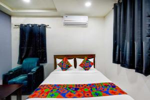 a small room with a bed and a chair at FabHotel Aashvi in Hyderabad