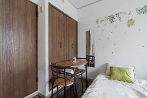 a bedroom with a bed and a table in a room at 3 minutes walk from Minami Fukuoka Station, free Wi-Fi in Fukuoka