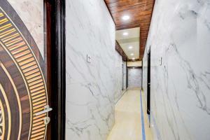 ハイデラバードにあるFabHotel Devara Grandの白い大理石の壁と木製の天井のある廊下