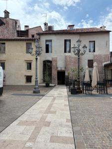 a building with tables and chairs in a courtyard at Elegante appartamento nel cuore di Bassano in Bassano del Grappa