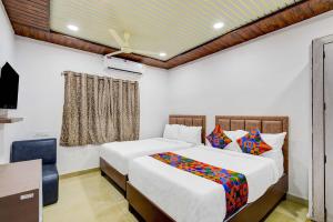 ハイデラバードにあるFabHotel Devara Grandのベッド2台、机、テレビのある寝室 +30枚の写真