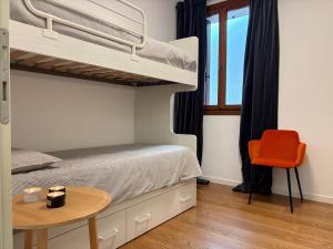 a bedroom with a bunk bed with a table and a chair at Elegante appartamento nel cuore di Bassano in Bassano del Grappa