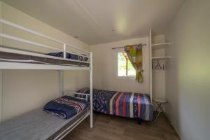 Un dormitorio con dos literas y una ventana. en Camping Le Barutel, en Meyras 21 fotos más