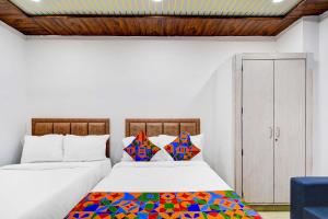 ハイデラバードにあるFabHotel Devara Grandのカラフルな枕付きのベッド2台