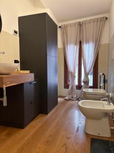 a bathroom with two sinks and two toilets at Elegante appartamento nel cuore di Bassano in Bassano del Grappa +14 photos