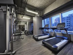 een sportschool met loopbanden en crosstrainers bij Ningbo Wanda Moments Hotel in Ningbo