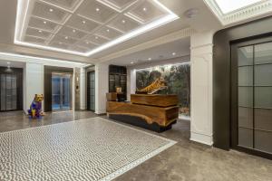 ハイデラバードにあるZIBE Luxe Hyderabad by GRT Hotelsのピアノと壁に絵が飾られたロビー