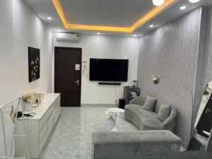a living room with a couch and a tv at Grand C Homestay in Hanoi