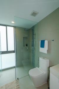 une salle de bain avec des toilettes blanches et une douche dans l'établissement Oceanstone condo in Laguna, 2-BR 90 sqm, BangTao Beach, à Bang Tao Beach