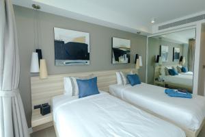 une chambre d'hôtel avec deux lits et un miroir dans l'établissement Oceanstone condo in Laguna, 2-BR 90 sqm, BangTao Beach, à Bang Tao Beach 32 autres photos