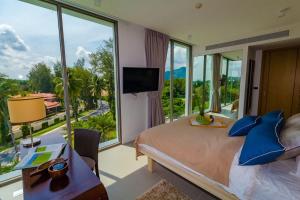 une chambre avec un lit et une grande fenêtre dans l'établissement Oceanstone condo in Laguna, 2-BR 90 sqm, BangTao Beach, à Bang Tao Beach