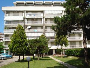 un immeuble d'appartements avec des arbres devant dans l'établissement Apartment in Porto Santa Margherita 42870, à Porto Santa Margherita