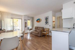 Una cocina y una sala de estar con un sofá y una mesa. en Michelangelo - PlanetCostaDorada, en Salou