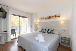 Un dormitorio blanco con una cama grande y una ventana. en Michelangelo - PlanetCostaDorada, en Salou 29 fotos más