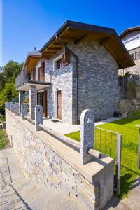 a stone house with a fence in front of it at Villa Graziosa in Trarego