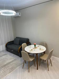 a living room with a table and chairs and a bed at Elexus Estate in Astana