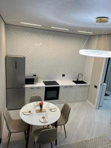 a kitchen with a white table and chairs and a kitchen with a counter at Elexus Estate in Astana