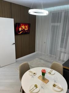 a dining room with a table with chairs and a fireplace at Elexus Estate in Astana