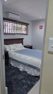 a bedroom with a large bed with a window at Ntale Guest House in Benoni +23 photos