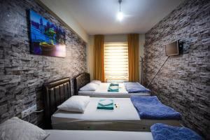 a room with three beds and a tv on the wall at OTEL 22 EDiRNE in Edirne