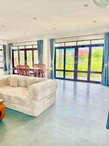 een woonkamer met een witte bank en een tafel bij Baan Suan Poolsap - Haad Rin Beach in Haad Rin