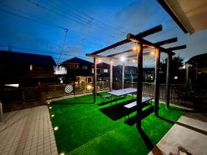 a backyard with a picnic table on a green lawn at Guest House YADOKARI 駐車場なし in Hirakata