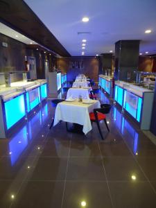 une salle à manger avec deux tables dans un restaurant dans l'établissement Hotel Emilio Moretti, à Laâyoune