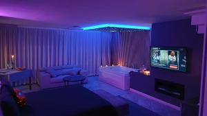 a purple living room with a couch and a tv at Luxury Suite Quartu in Quartu SantʼElena