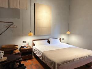 een slaapkamer met een bed en 2 hanglampen bij Not just Tea Space in Quanzhou