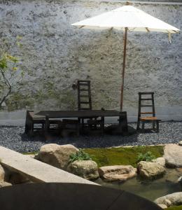 een tafel en twee stoelen en een parasol en een vijver bij Not just Tea Space in Quanzhou