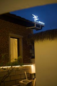 een bord aan de zijkant van een gebouw 's nachts bij Not just Tea Space in Quanzhou +16 foto's