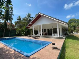 a swimming pool in front of a house at Paradise House in Thai Muang
