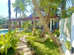 a house with palm trees and a swimming pool at Double W Grand Villa Madiha in Matara