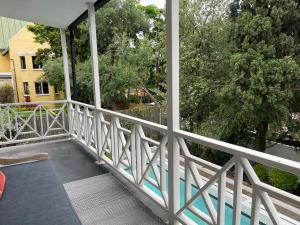 einen Balkon mit weißem Geländer und Bäumen in der Unterkunft Sandton Farmhouse in Johannesburg