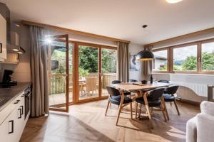 ヴェステンドルフにあるAppartements Barbaraのテーブルと椅子のあるキッチンとダイニングルーム