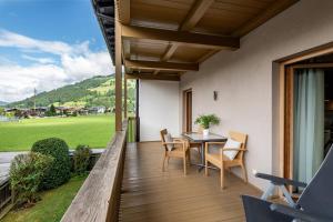 ヴェステンドルフにあるAppartements Barbaraの木製バルコニー(テーブル、椅子付)